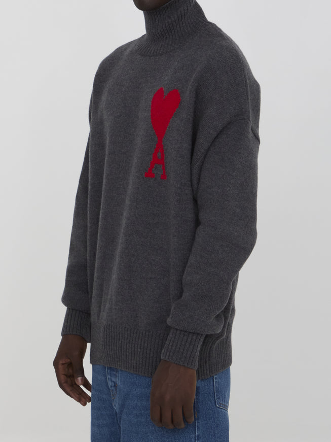 a man wearing a grey sweater with a red heart on it