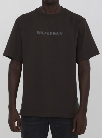 a man wearing a brown shirt with the word ordinary printed on it