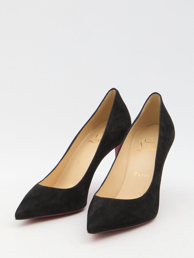 a pair of black high heeled shoes on a white surface