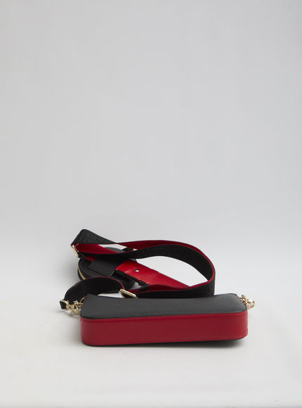 a red and black purse sitting on top of a white table