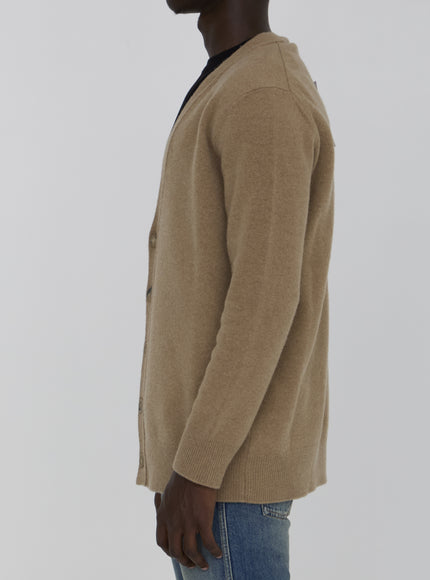 a man wearing a tan sweater and jeans