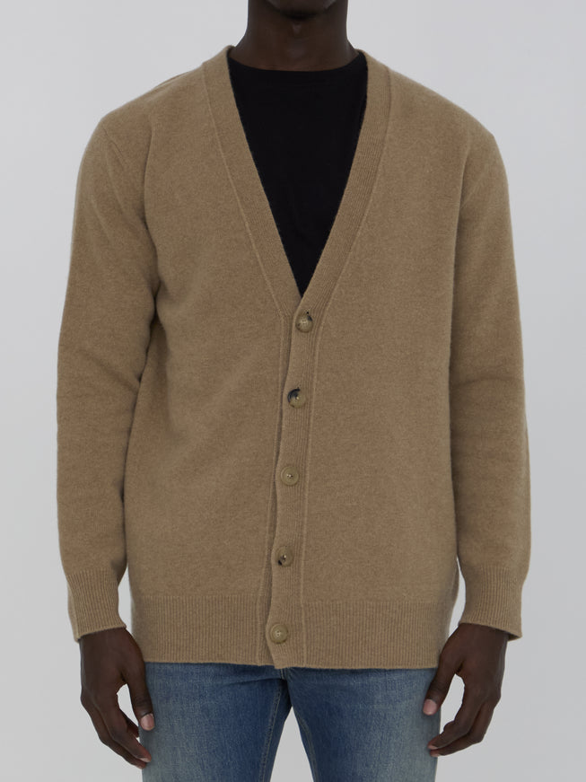 a man wearing a brown cardigan sweater and jeans