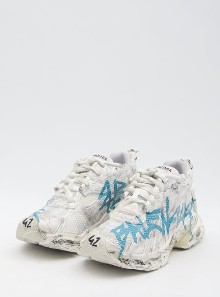 a pair of white sneakers with blue graffiti on them