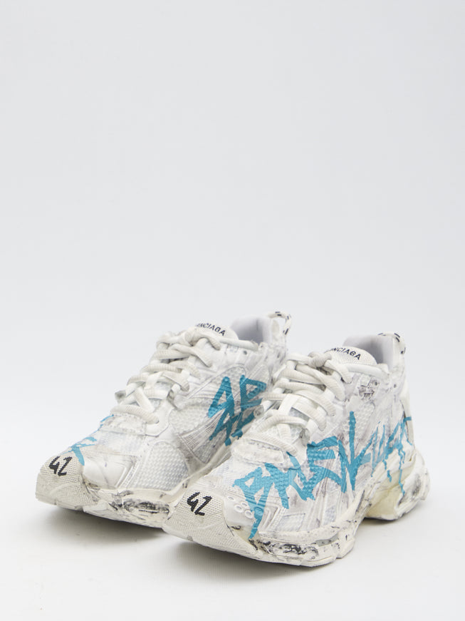 a pair of white sneakers with blue graffiti on them