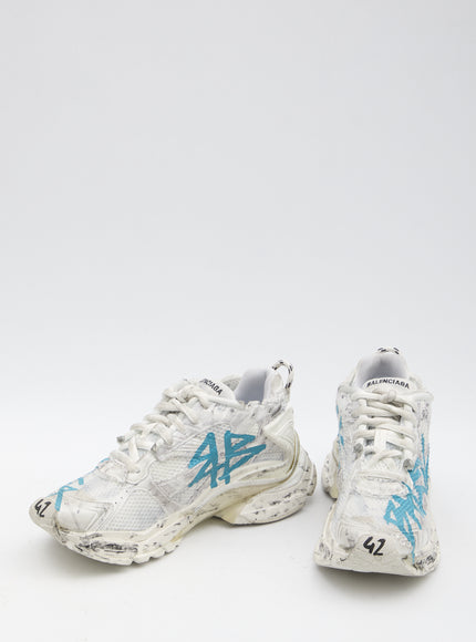 a pair of white and blue sneakers on a white surface