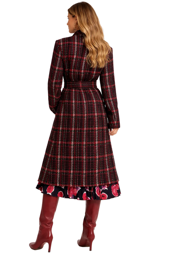 Woman wearing a Marni plaid dress with a floral hem and red boots on a white background
