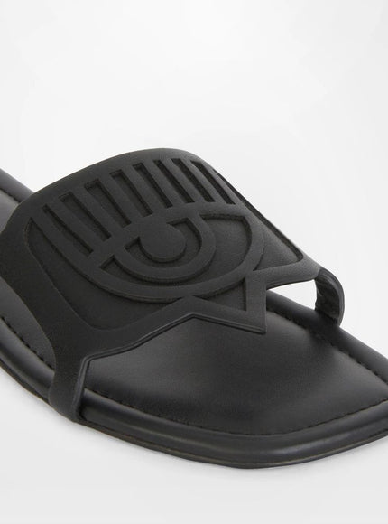 a close up of a black slipper with an eye on it