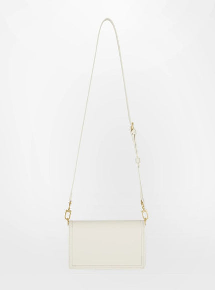 a white handbag with a long strap