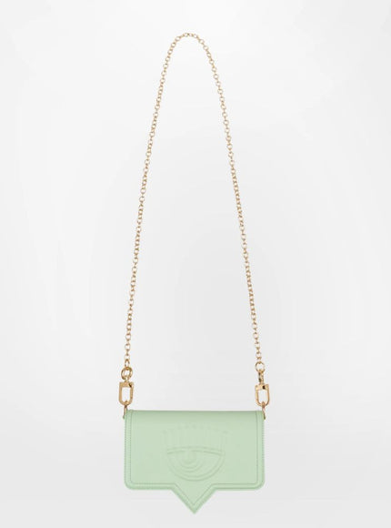 a green bag hanging from a gold chain