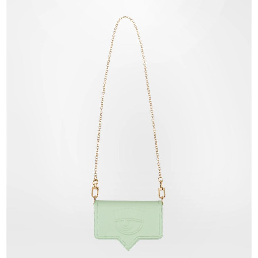 a green bag hanging from a gold chain